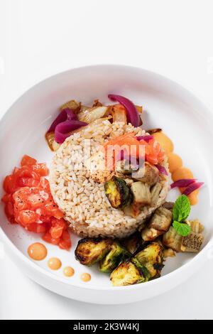 Poke with brown rice, salmon and grilled vegetables Stock Photo