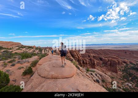 People walking along a trail on the top of the sandstone with specatular view in Arches National Park in Utah USA Stock Photo