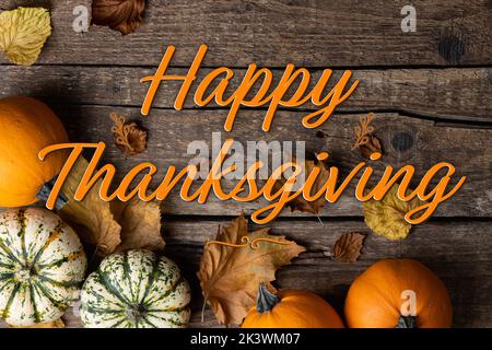 Happy Thanksgiving. Thanksgiving background with pumpkins and autumn leaves on rustic wooden background. Autumn composition - Thanksgiving greeting ca Stock Photo