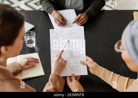 High angle close up of two female HR managers holding CV of candidate at job interview Stock Photo