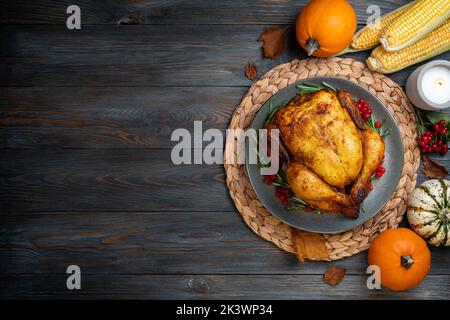 Thanksgiving Greetings. Roasted chicken or turkey for festive dinner on wooden table. Thanksgiving Day concept. Copy space Stock Photo