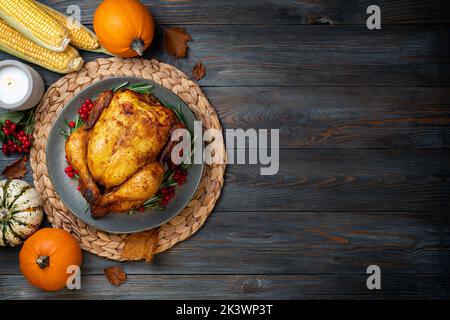 Thanksgiving Greetings. Roasted chicken or turkey for festive dinner on wooden table. Thanksgiving Day concept. Copy space Stock Photo