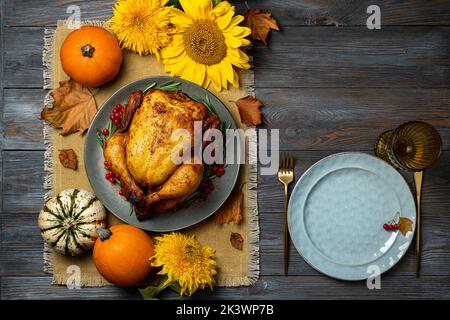 Festive table setting, roasted chicken or turkey for Thanksgiving Day on wooden table. Fried chicken, pumpkins for Thanksgiving dinner. Thanksgiving, Stock Photo