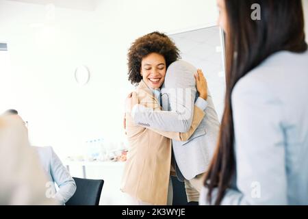 hug hugging coworker love partner office business happy relationship Stock Photo