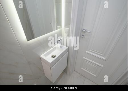 Small white hand wash sink and vanity mirror Stock Photo