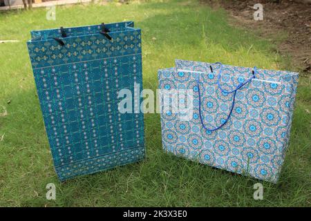 Colorful Paper Shopping bags are isolated on a green natural background. no plastic bags only eco-friendly bags. Stock Photo