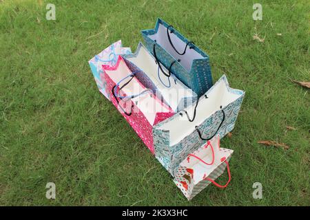 Colorful Paper Shopping bags are isolated on a green natural background. no plastic bags only eco-friendly bags. Stock Photo