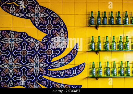 2017 06 10 Progreso Yucatan Mexico - Interesting Design of Tavera tiles on wall of Mexican restaurant near beach with bottles of Heineken Beer on Glas Stock Photo