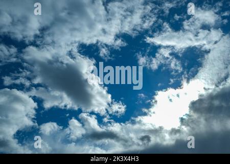 Blue sky with thunderclouds. The sun breaks through the clouds. Black clouds. Stock Photo