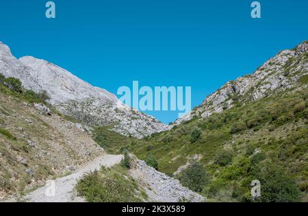 Camino de tierra entre montaÃ±as rocosas en el valle de Mazobre del parque natural de la montaÃ±a Palentina, EspaÃ±a Stock Photo