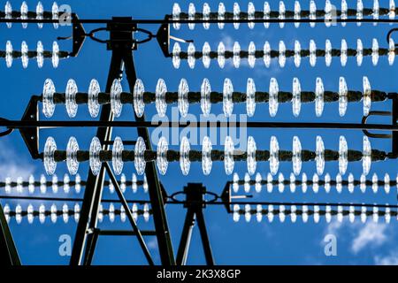 Insulators made of glass on a high-voltage line, on the poles they hang as a suspension device between the pole and the live, non-insulated cable, ext Stock Photo