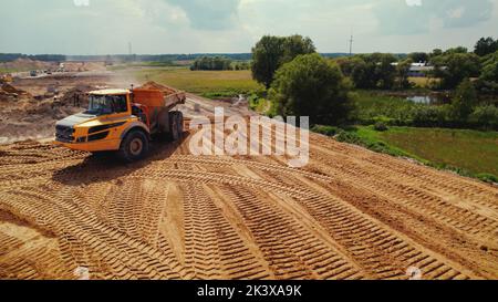 A dumper truck loaded with earth, transporting it. Heavy construction machinery working on a road building site in Warsaw, Poland. High quality photo Stock Photo