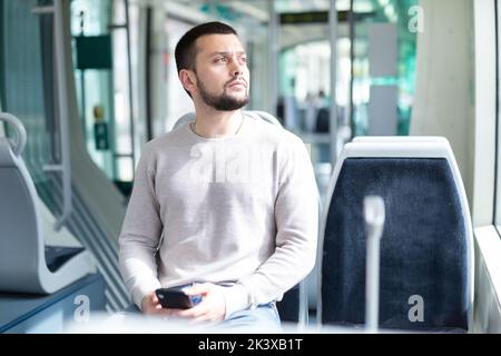 Young man using smartphone during trip in public transport Stock Photo