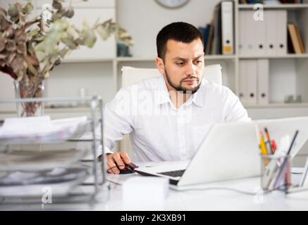 Man office worker using laptop during workday Stock Photo
