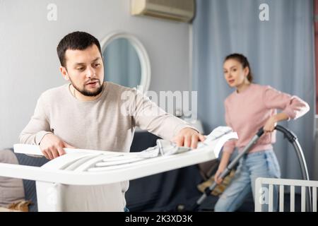Young couple cleaning table in living room Stock Photo