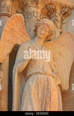 The Smiling Angel (Smile of Reims), carved between 1236-1245, on the north portal of the west facade of Reims Cathedral (Marne), France Stock Photo