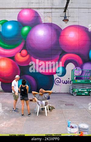 Artist Wing Chow creates a new mural during the 2022 RVA Street Art Festival at the Power Plant along Richmond VA's Canal Walk. Stock Photo