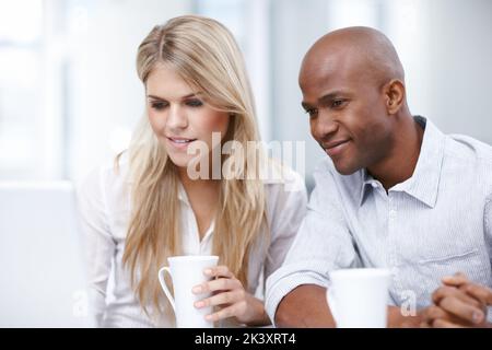 Thinking of some solutions. Two young businesspeople working together on a project. Stock Photo