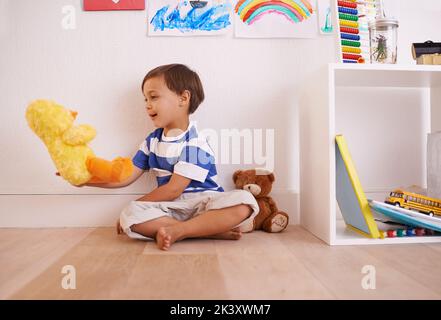 He loves his fuzzy little friends. a little boy playing with his toys in his room. Stock Photo