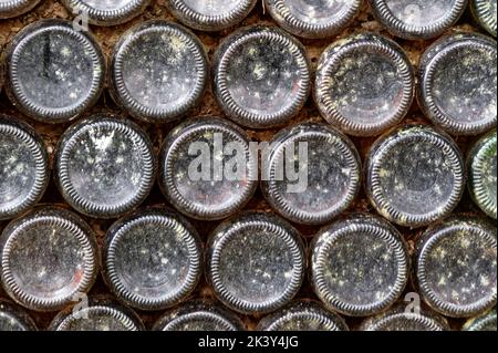Rows of old bottles form lines in a bank, a creative use of them. Stock Photo
