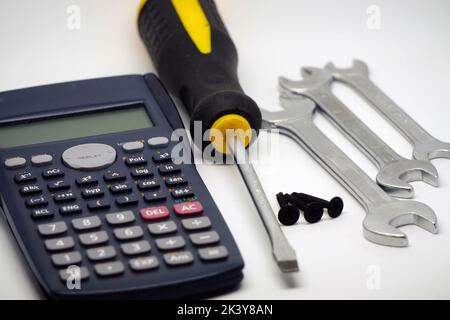 A calculator and screwdrivers isolated on the white background, close-up Stock Photo