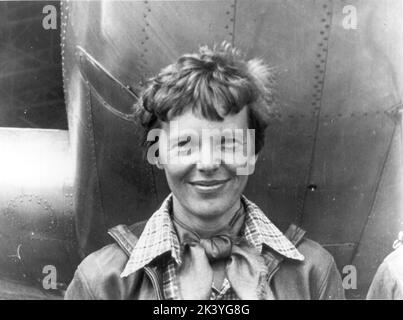 Amelia Earhart standing under nose of her Lockheed Model 10-E Electra - 1937 Stock Photo