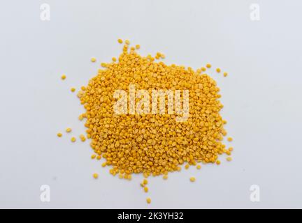 Pile of Yellow lentils or Moong Beans isolated on uneven white background. Selective Focus on center. Stock Photo