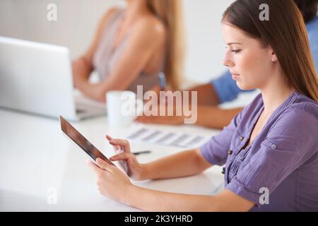 Taking some notes online. Cropped view of a casual young businesswoman using a tablet. Stock Photo