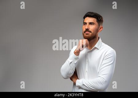Studuo shot of thinking businessman standing over gray background Stock Photo