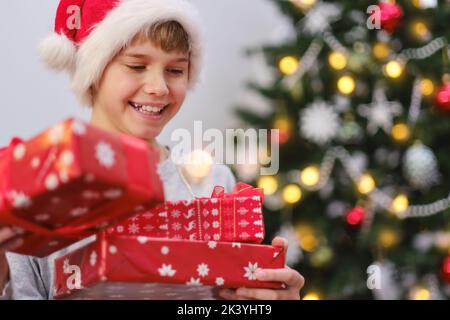 Cheerful boy holding his presents on a Christmas morning. Stock Photo