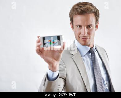 Want to see the charts. A young businessman holding a piechart to the camera. Stock Photo