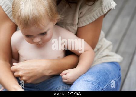 Secure in his mothers love. a baby boy being held by his mother. Stock Photo