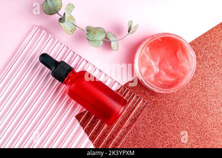 Top view of skin exfoliation cosmetic set. Liquid peeling serum with enzymes and fruit acid scrub with small particles in red packaging. Skin care cos Stock Photo