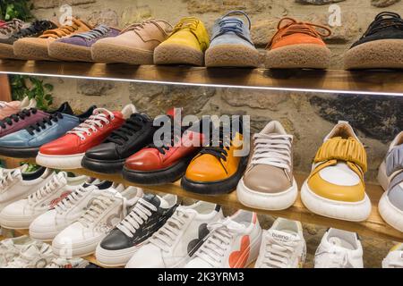 Berlin, Germany - March 13, 2022: colorful boots in shop, variety of shoes in store Stock Photo