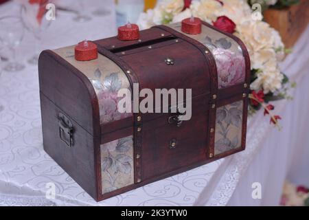 Old wedding coffer for money with red candles Stock Photo