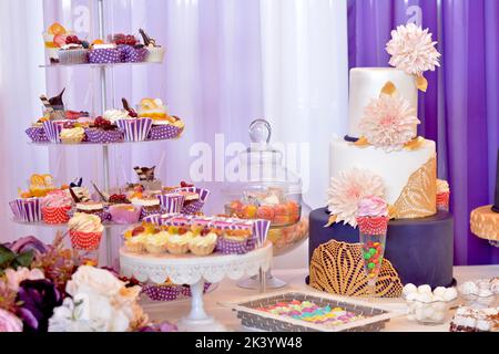 Candy bar. Table with sweets, candies, dessert. Cake with big beige chrysanthemums. Stock Photo