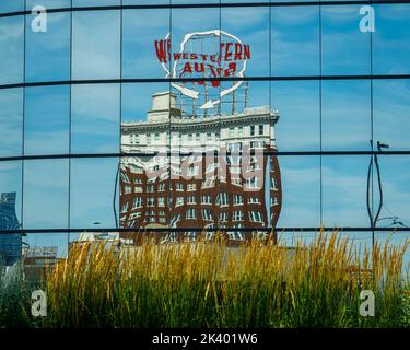 A western auto building reflected in windows of a hotel Stock Photo
