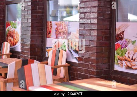 Colored wooden chairs and tables. Terrace of a fast food restaurant. Stock Photo