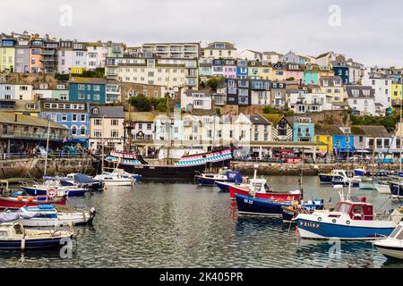 Colourful houses and shops overlooking the inner harbour with small boats moored. Brixham, Devon, England, UK, Britain Stock Photo