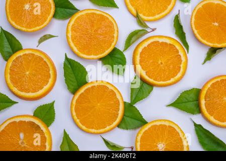 background with slides of orange and leaves on a white background, trendy summer, fruity background. Stock Photo