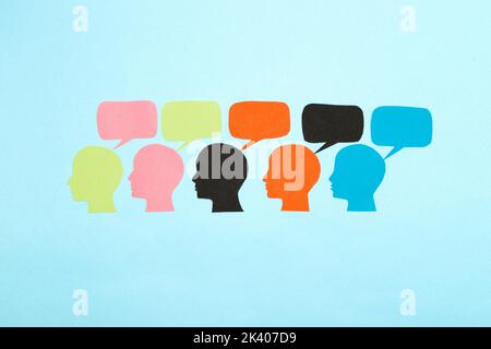 colorful heads with bubbles above, social communication background, flat lay, paper craft Stock Photo