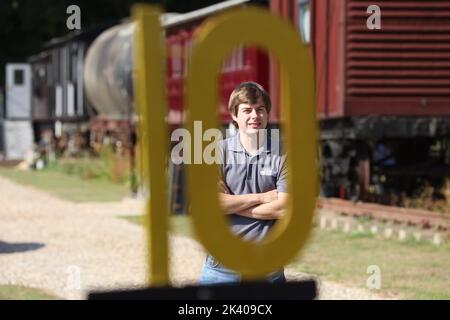 James Waters (with Dad Robin) alongside the 1880s train carriage which they one an award for as a quirky holiday letting property, Halstead, Essex UK Stock Photo