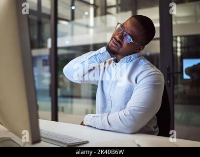 Burnout, stress and neck pain by businessman working on a computer late in office, injury and discomfort. Corporate employee suffering from hurt and Stock Photo