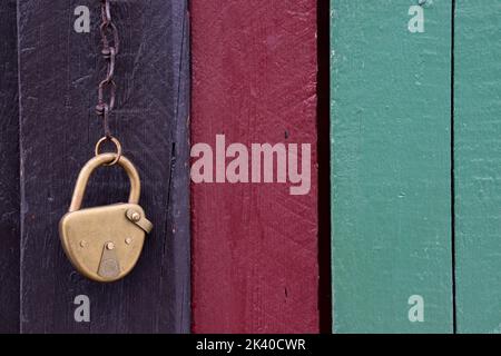 antique brass padlock hanging on a wooden door Stock Photo