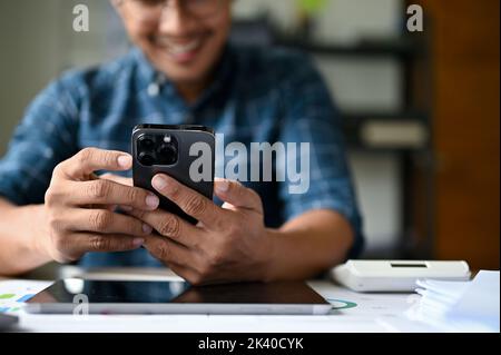Happy Asian businessman or male office worker enjoys chatting with his girlfriend during work in his office. close-up hands image Stock Photo