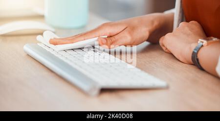 Clean, office and woman hands cleaning computer keyboard with a wipe for hygiene, cleaniness and disinfection of workspace for bacteria, virus or Stock Photo