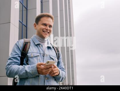 Young smiling man is holding cell phone Stock Photo