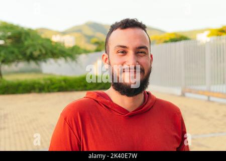 Portrait of a handsome young Latino man standing in the park. Stock Photo