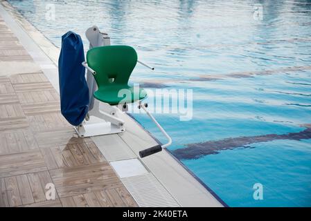 Swinging arm disabled chair. Swimming pool lift with a chair Stock ...