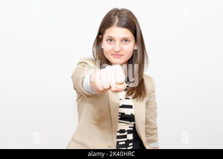 Angry young woman shows fist, Studio Shot stock photo Stock Photo